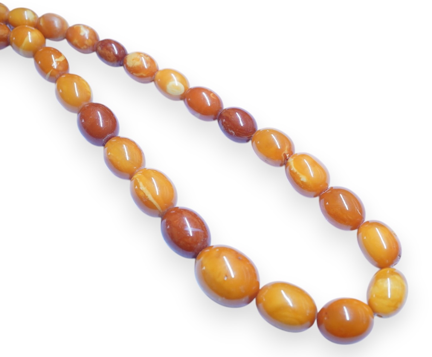 A single strand graduated oval amber bead necklace, 110cm, gross weight 103 grams. Condition - poor to fair